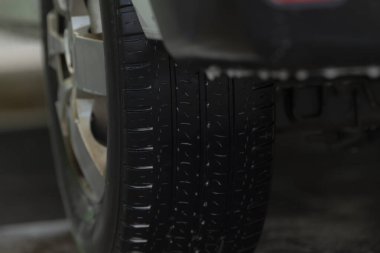 Mürekkep izleri, sırılsıklam lastik izleri belirgin çıkıntılar ve sıkı tutunma özellikleri, yoğun kanallar ve aydınlatma altında güçlü çekiş dizaynı gösteren suyla kaplı lastik desenleri.