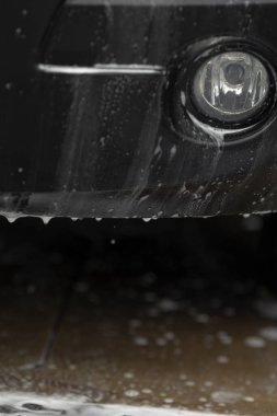 Beton üzerine su damlayan alt tampon, kişisel servis yıkama sahnesi, desenli ızgara boyunca uzanan sabun birikintisi, drenaj ve şasi spreyinin kapatılması, kentsel temizlik eylemleri