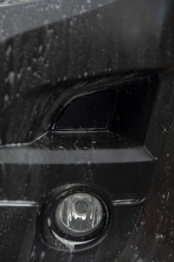 Su akımlı siyah tampon lambası, seyyar temizleyici durulama, parlak yansıma, sabun film ve plastik süsleme üzerindeki damlacıklar, desen ve kontur gösteren kiralanma, kentsel garaj ışıklandırması