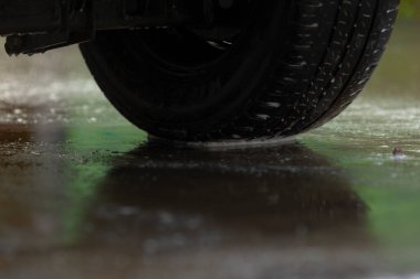 Rutubetli kauçuk yansıma, yansıtıcı ıslak lastik yüzeyi detaylı lastik izi açıkça görülüyor, nemli kauçuk lastik kalıpları beton yüzeyde parlak yansıma, karmaşık lastik dizaynını gösteriyor