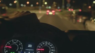 Gece vakti şehir trafiği, loş ışıklandırma koşulları altında şehir yollarında bireysel işletim aracı, gece geç saatlerde sakin kentsel caddelerde arabayı dikkatle kullanan kişi.