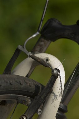 Detaylı bisiklet parçası, mekanik parçaların yakın görünümü, çamurlu fren ve çamurluk detaylarına odaklan, Paslı kalibreli ve yıpranmış bisiklet bakımına odaklan