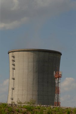 bitişik kırmızı servis kulesine sahip beton soğutma kulesi, desenli silindirik yüzey ve bulutlu gökyüzü, büyük ölçekli enerji altyapısı ve sanayi