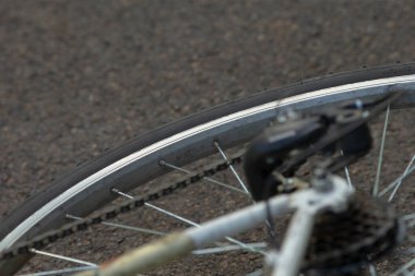 Bisiklet lastiği kazası, cadde kenarındaki bisiklet tekerleği hasar görmüş acil tamirat gerektiren, şehir sokaklarında dinlenen bozuk bisiklet tekerleğinin kapatılması mekanik arızayı gösteriyor.