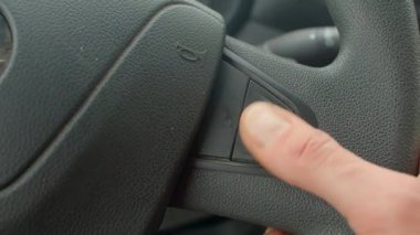 Yakından başparmağınla kontrol düğmesine bas, direksiyon detayına dokunun, başparmak ayarları R O anahtarı, sakin şehir trafiği sırasında dokunsal geri besleme, kontrollerle modern araba iç etkileşimi