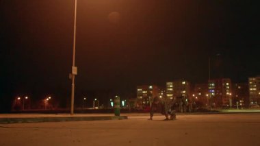 Şehir koşucuları, şehrin karanlığında aydınlık lambaların altında koşuşturan aktif figürler, sessiz gece saatlerinde ıssız şehir sokaklarında parlayan sokak lambaları altında yarışan iki kişi.