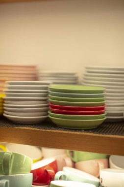 Ahşap rafta düzgünce istiflenmiş kâseler ve fincanlar, restoran iç depolama sahnesi katmanlı pastel tabaklar ve günlük kahve cazibesine sahip uçan daireler ve etkin arka plan düzenlemeleri hazır.