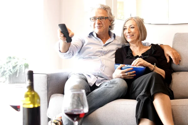 Patlamış mısır yemek ve tv izlerken yaşlı çift