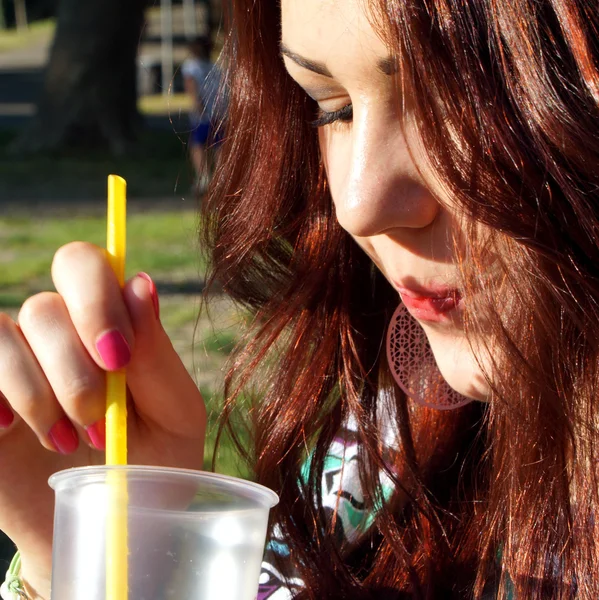 公園でスラッシュを食べる若い女性 — ストック写真