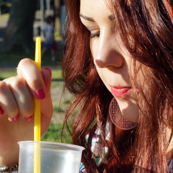 Young lady eating slush in the park — Stock Photo, Image