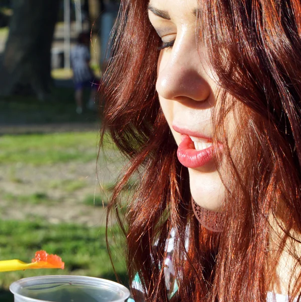 Giovane signora mangiare melma nel parco — Foto Stock