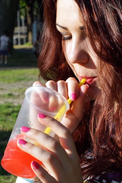 Young lady eating slush in the park — Stock Photo, Image