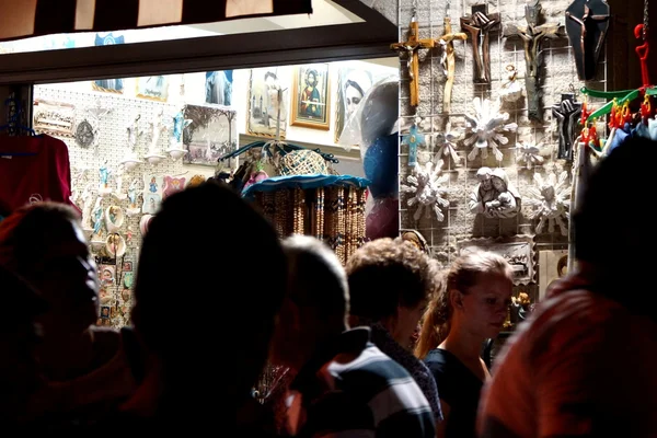 Medjugorje, Citluk, Bosnia and Herzegovina - August 14, 2015: Pilgrims just arrived with bus pass in front of shops of religious items on the slopes of Mount Podbrdo in Medjugorje — Stock Photo, Image