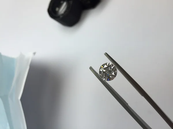 Круглый алмаз, удерживаемый пинцетом — стоковое фото