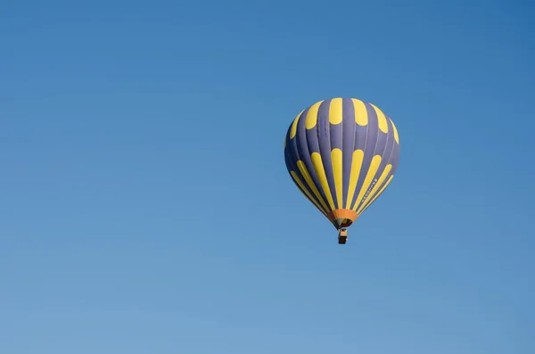 Balon na ogrzane powietrze latające nad czystym, błękitnym niebie — Zdjęcie stockowe