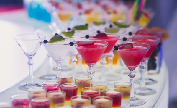 Beautiful row line of different colored alcohol cocktails with mint on a party — Stock Photo, Image