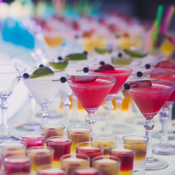 Schöne Reihe verschiedenfarbiger Alkoholcocktails mit Minze auf einer Party — Stockfoto