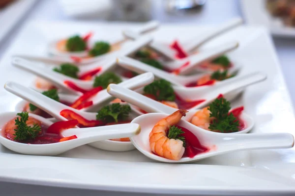 Beautifully decorated catering banquet table with different food snacks and appetizers with sandwich, caviar, fresh fruits on corporate christmas birthday party