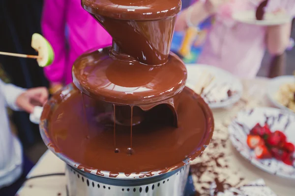 Vibrant chocolate fountain on kids birthday party — Stock Photo, Image