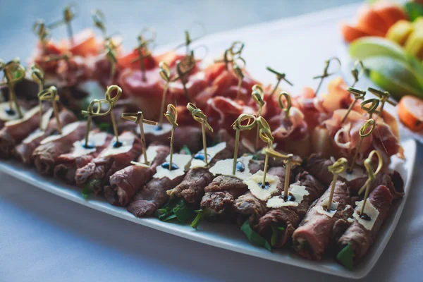 Mesa de banquete de catering lindamente decorada com diferentes lanches e aperitivos de alimentos — Fotografia de Stock