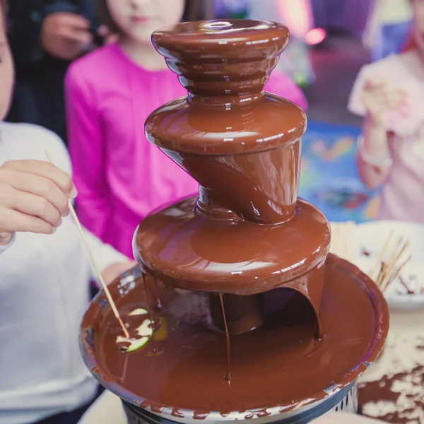 Vibrant chocolate fountain on kids birthday party — Stock Photo, Image