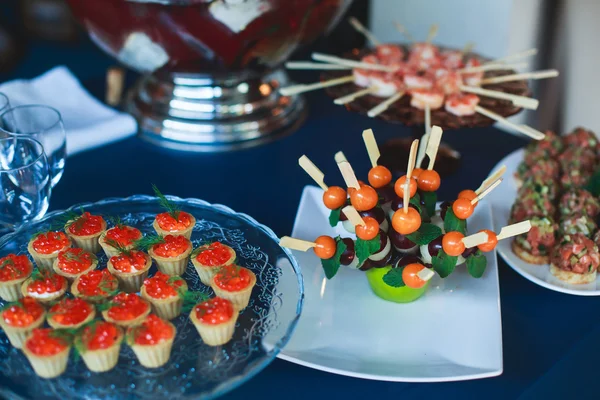 Mesa de banquete de catering lindamente decorada com diferentes lanches e aperitivos de alimentos — Fotografia de Stock