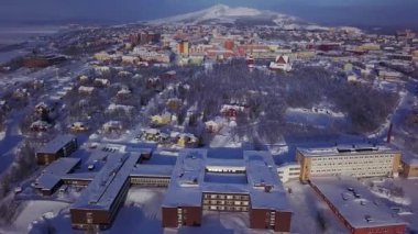 İsveç 'in en kuzeyindeki şehir olan Kiruna' nın kış manzarası. Kışın insansız hava aracından çekilmiş güneşli bir görüntü.