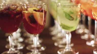 Yemek masasında alkol ayarı, parti, martini, votka, spritz ve dekore edilmiş yemek masasında farklı renkte alkol kokteylleri.