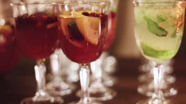 Yemek masasında alkol ayarı, parti, martini, votka, spritz ve dekore edilmiş yemek masasında farklı renkte alkol kokteylleri.