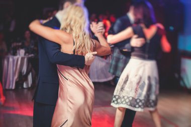 Couples dancing traditional latin argentinian dance milonga in the ballroom hall, tango salsa bachata kizomba lesson in the red lights, dance festival 