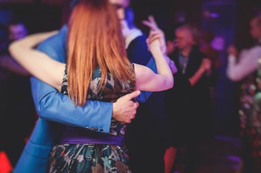 Couples dancing traditional latin argentinian dance milonga in the ballroom hall, tango salsa bachata kizomba lesson in the red lights, dance festival 
