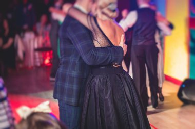 Couples dancing traditional latin argentinian dance milonga in the ballroom hall, tango salsa bachata kizomba lesson in the red lights, dance festival 