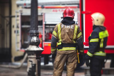 İtfaiye ekipleri, itfaiyeciler, arka planda itfaiye aracı olan itfaiyeciler, acil durum. 