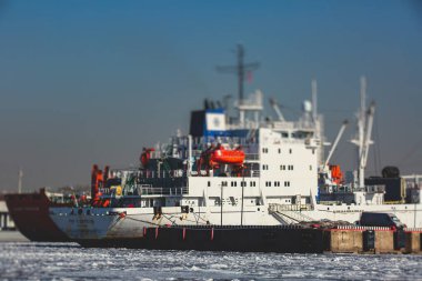 Buzda sıkışmış çok sayıda farklı gemi buzullar, buzkıran ve taşıyıcı gemi ve kış mavisi gökyüzü arasındaki körfezi kırmaya ve terk etmeye çalışıyor.