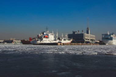 Buzda sıkışmış çok sayıda farklı gemi buzullar, buzkıran ve taşıyıcı gemi ve kış mavisi gökyüzü arasındaki körfezi kırmaya ve terk etmeye çalışıyor.