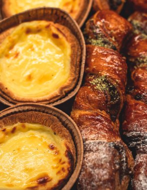 Hamur işleri, farklı fırınlar, kruvasan, İsviçre dürümleri, kek, ekler ve bir sepette ya da tabakta diğerleri, fırında tatlı, yemek servisi ya da kafe ziyafeti masası. 