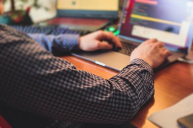 IT geliştirici programcısı evinde, bilgisayarında ve masaüstü monitöründe kodlama programı uygulaması ile çalışıyor ve kodluyor, uzaktan kumanda evden çalışıyor, sıcak akşam resmi