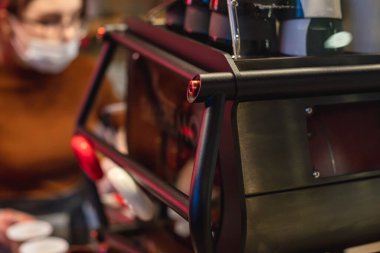 Kafe barında kahve makinesinde çalışan kadın kahveci, solunum maskesi takan barmen cappuccino yapan barmen, kafe reyonunda kahve hazırlayan barmen.