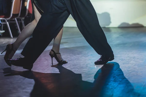 Dancing shoes of young couple, Couples dancing traditional latin argentinian dance milonga in the ballroom, tango salsa bachata kizomba lesson, dance festival, wooden floor, close view of shoes