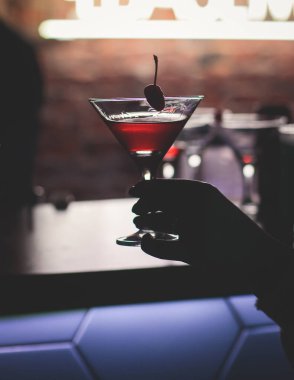 Gece kulübü partisinde barın tezgahında farklı renkte içki kokteylleri, tekila, martinili bardaklar, votka, spritz ve dekore edilmiş yemek masası üzerindeki diğerleri.