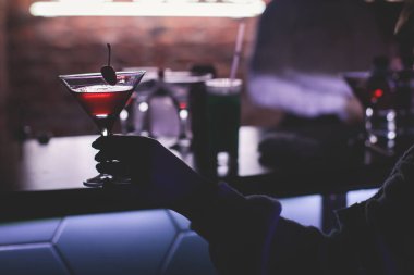 Gece kulübü partisinde barın tezgahında farklı renkte içki kokteylleri, tekila, martinili bardaklar, votka, spritz ve dekore edilmiş yemek masası üzerindeki diğerleri.