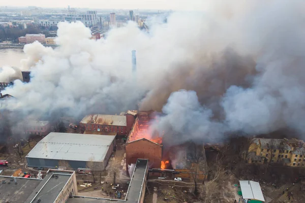 城里大火熊熊燃烧 空中无人机俯瞰砖厂大楼着火 地狱大火熊熊燃烧 消防队员们携手并肩 焚烧破坏 — 图库照片