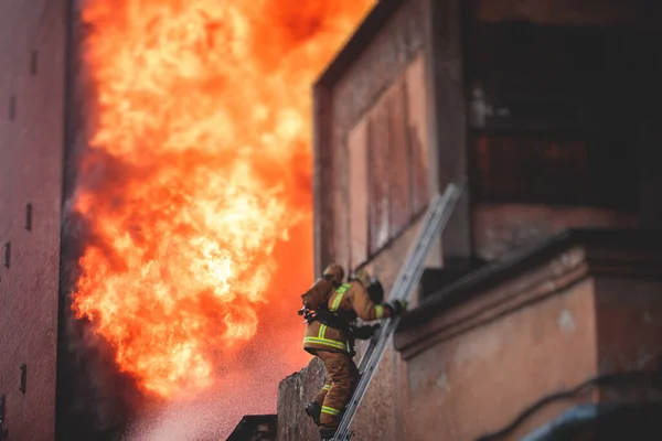 Firefighters put out large massive fire blaze, group of fire men in uniform during fire fighting operation in the city streets, firefighters with fire engine truck fighting vehicle