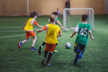 Çocuklar için futbol maçı, bir grup çocuk futbol takımı antrenman yapıyor, ya da sahada futbol maçı, yeşil sahada koşmak ve topa vurmak.