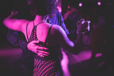 Balo salonunda geleneksel Latin dansı milongası yapan çiftler, kırmızı, mor ışıklar altında tango salsa bachata kizomba dersi, dans festivali 