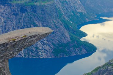 Yürüyüş yer - trolltunga, troller dil, bir turist ile kaya skjegedall ve göl ringedalsvatnet ve dağ panoramik manzara epik görünümü, Norveç ünlü Norveçli canlı bir resmini