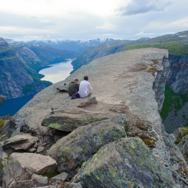 Yürüyüş yer - trolltunga, troller dil, bir turist ile kaya skjegedall ve göl ringedalsvatnet ve dağ panoramik manzara epik görünümü, Norveç ünlü Norveçli canlı bir resmini