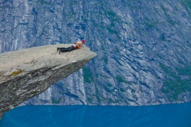 Yürüyüş yer - trolltunga, troller dil, bir turist ile kaya skjegedall ve göl ringedalsvatnet ve dağ panoramik manzara epik görünümü, Norveç ünlü Norveçli canlı bir resmini