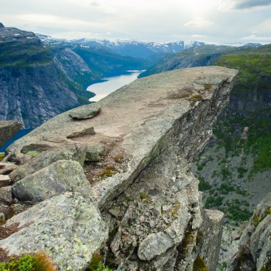 Yürüyüş yer - trolltunga, troller dil, bir turist ile kaya skjegedall ve göl ringedalsvatnet ve dağ panoramik manzara epik görünümü, Norveç ünlü Norveçli canlı bir resmini