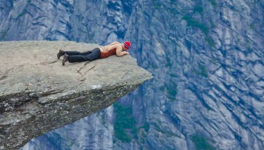 Yürüyüş yer - trolltunga, troller dil, bir turist ile kaya skjegedall ve göl ringedalsvatnet ve dağ panoramik manzara epik görünümü, Norveç ünlü Norveçli canlı bir resmini